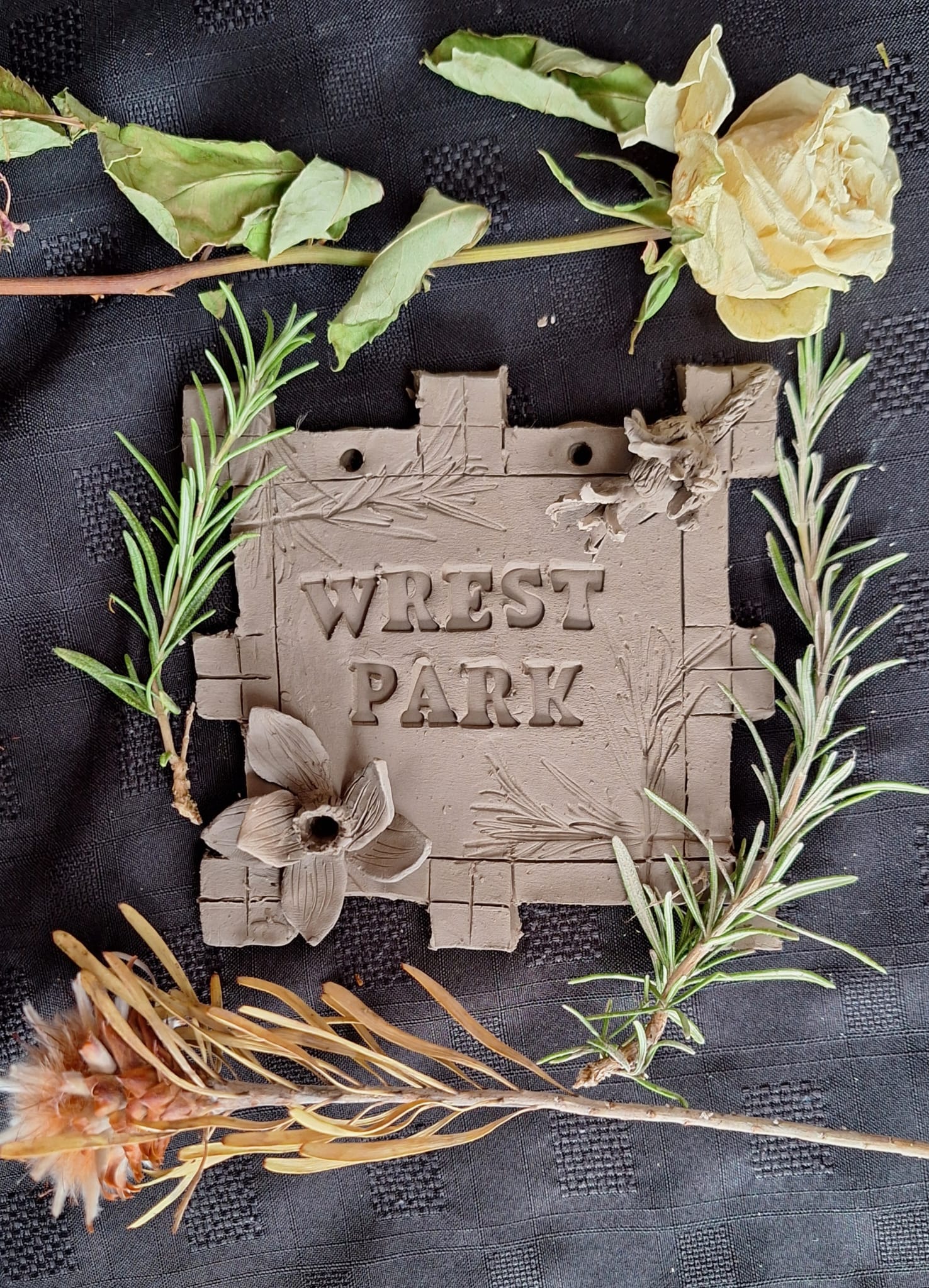 Hands working with clay and natural elements